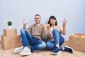 Young couple moving to a new home shouting with crazy expression doing rock symbol with hands up Royalty Free Stock Photo