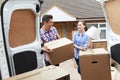 Young Couple Moving In To New Home Unloading Removal Van Royalty Free Stock Photo