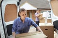 Young Couple Moving In To New Home Unloading Removal Van Royalty Free Stock Photo