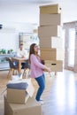 Young couple moving to a new house, woman holding cardboard boxes worried about falling for overweight Royalty Free Stock Photo