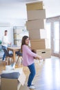 Young couple moving to a new house, woman holding cardboard boxes worried about falling for overweight Royalty Free Stock Photo