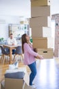 Young couple moving to a new house, woman holding cardboard boxes worried about falling for overweight Royalty Free Stock Photo