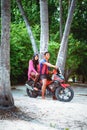 Young couple of muslim sitting on morcicle in the beach of island small village