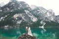 Young couple near lake Karersee, Italy. Holding hands at the stone at lake