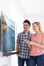 Young Couple With New Curved Screen Television At Home Royalty Free Stock Photo