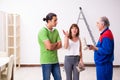 Young couple and old contractor in home renovation concept Royalty Free Stock Photo