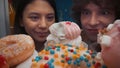 A young couple at an open refrigerator filled with desserts close up. A European man and an Asian woman are both looking Royalty Free Stock Photo