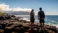 Couple overlooks the ocean off a rocky Kauai coast