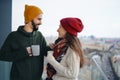 Young couple owners with tea on balcony in new flat, moving in, new home and relocation concept.