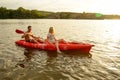 Young Couple Paddling Kayak on Beautiful River or Lake in the Evening at Sunset Royalty Free Stock Photo