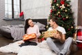 Young couple in pajamas rejoice at their presents while sitting Royalty Free Stock Photo