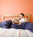 Young Couple in Pajamas Sitting on Bed Royalty Free Stock Photo