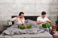 Young couple in pajamas unpacking their presents while sitting o Royalty Free Stock Photo