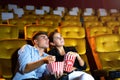 Young couple people watching movie feeling scary and frightening at movie theater. In hand holding snack bucket and throw popcorn Royalty Free Stock Photo