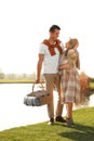 Young couple with picnic basket near lake Royalty Free Stock Photo