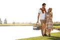 Young couple with picnic basket near lake Royalty Free Stock Photo