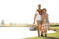 Young couple with picnic basket near lake Royalty Free Stock Photo