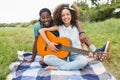 Young couple on a picnic playing guitar