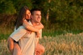 Young couple piggyback riding and watching sunset Royalty Free Stock Photo