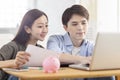 Young couple planning budget,looking at laptop screen, checking finances