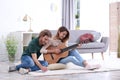 Young couple playing acoustic guitar and composing song in room Royalty Free Stock Photo