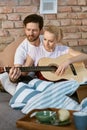 Young couple playing the guitar in bed Royalty Free Stock Photo