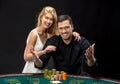 Young couple playing poker have a good time in casino
