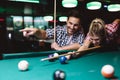 Young couple playing snooker together in bar Royalty Free Stock Photo