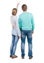 Young couple pointing at wal Back view (woman and man). Royalty Free Stock Photo