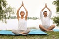 Young couple practicing yoga in park near lake Royalty Free Stock Photo
