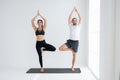 Young couple practicing yoga in a white room Royalty Free Stock Photo