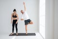 Young couple practicing yoga in a white room Royalty Free Stock Photo
