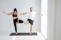 Young couple practicing yoga in a white room Royalty Free Stock Photo