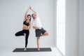 Young couple practicing yoga in a white room Royalty Free Stock Photo