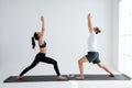 Young couple practicing yoga in a white room Royalty Free Stock Photo