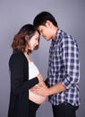 Young couple: pregnant mother and happy father on gray backgroun Royalty Free Stock Photo