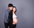 Young couple: pregnant mother and happy father on gray backgroun Royalty Free Stock Photo