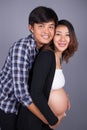 Young couple: pregnant mother and happy father on gray backgroun Royalty Free Stock Photo