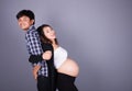 Young couple: pregnant mother and happy father on gray backgroun Royalty Free Stock Photo