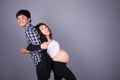 Young couple: pregnant mother and happy father on gray backgroun Royalty Free Stock Photo