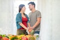 Young couple preparing extracted juices with fruit and vegetables during quarantine isolation - Happy wife and husband doing