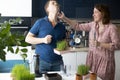 Young couple preparing green wheatgrass juice. Healthy antioxidant smoothie drink. Family fun