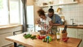 Young couple preparing a meal together in the kitchen. Italian man, chef cook helping his girlfriend to use hand blender Royalty Free Stock Photo