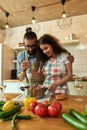 Young couple preparing a meal together in the kitchen, Italian man, chef cook helping his girlfriend to use hand blender Royalty Free Stock Photo