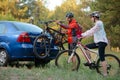 Young Couple Unmounting Mountain Bikes from Bike Rack on the Car. Adventure and Family Travel Concept. Royalty Free Stock Photo