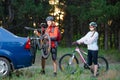 Young Couple Unmounting Mountain Bikes from Bike Rack on the Car. Adventure and Family Travel Concept. Royalty Free Stock Photo