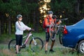 Young Couple Unmounting Mountain Bikes from Bike Rack on the Car. Adventure and Family Travel Concept. Royalty Free Stock Photo