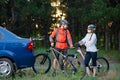 Young Couple Unmounting Mountain Bikes from Bike Rack on the Car. Adventure and Family Travel Concept. Royalty Free Stock Photo