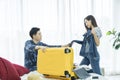 Young Couple are preparing to travel. Happy young friends packing clothes put in suitcase on bedroom. Female and Male using Royalty Free Stock Photo