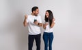 Young couple pumping fists and screaming excitedly after receiving goods news over smart phone. Ecstatic man and woman looking at